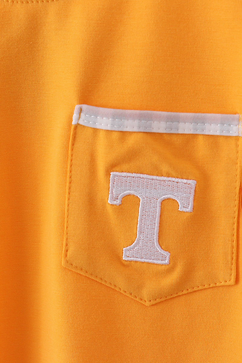 Close-up of a pocket with a 'T' logo on an orange background