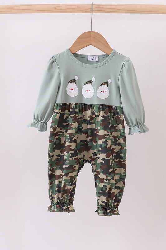 Two-piece outfit with green top and camouflage pants on a hanger against a white background