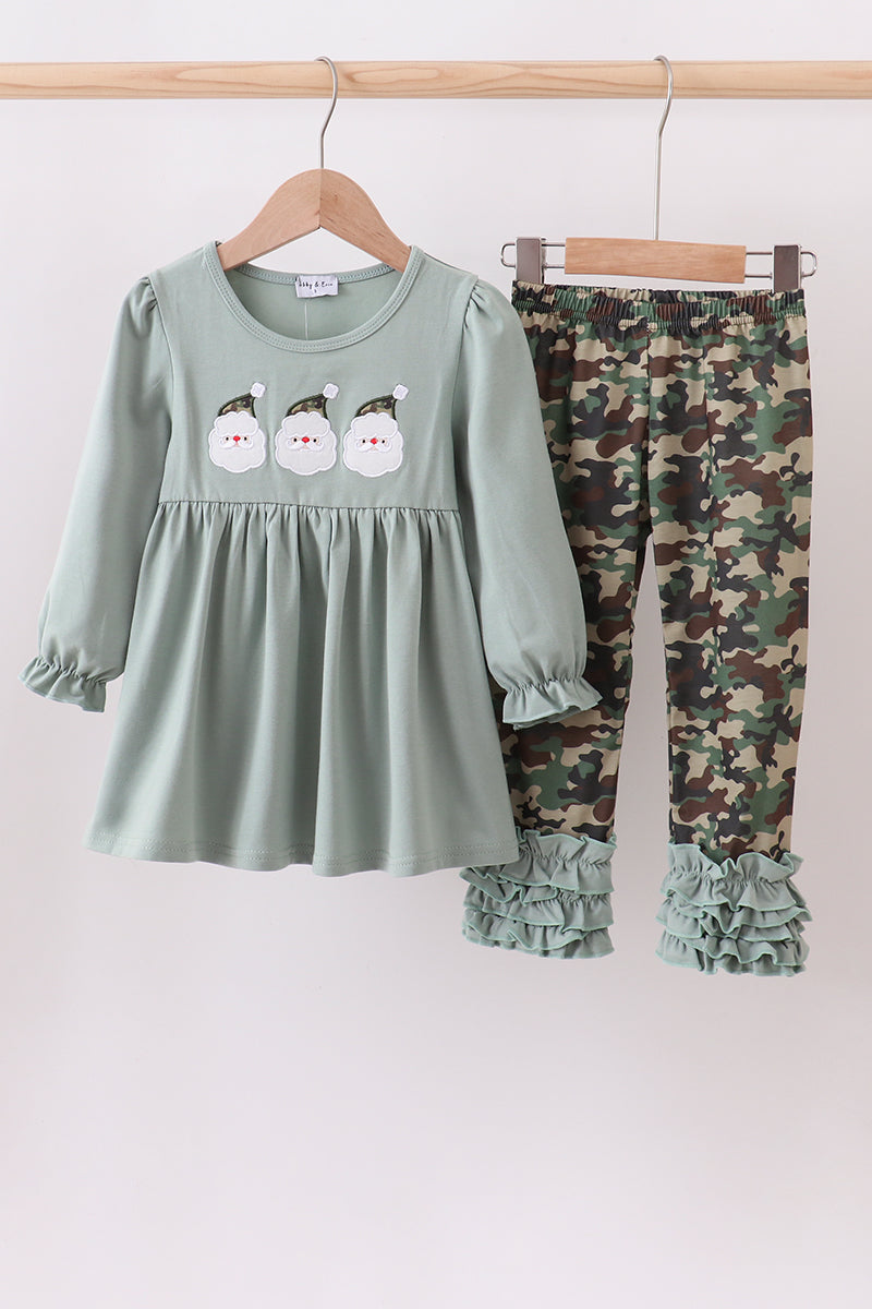 Children's outfit with green dress and camouflage pants on a white background