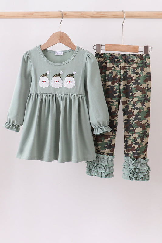 Children's outfit with green dress and camouflage pants on a white background