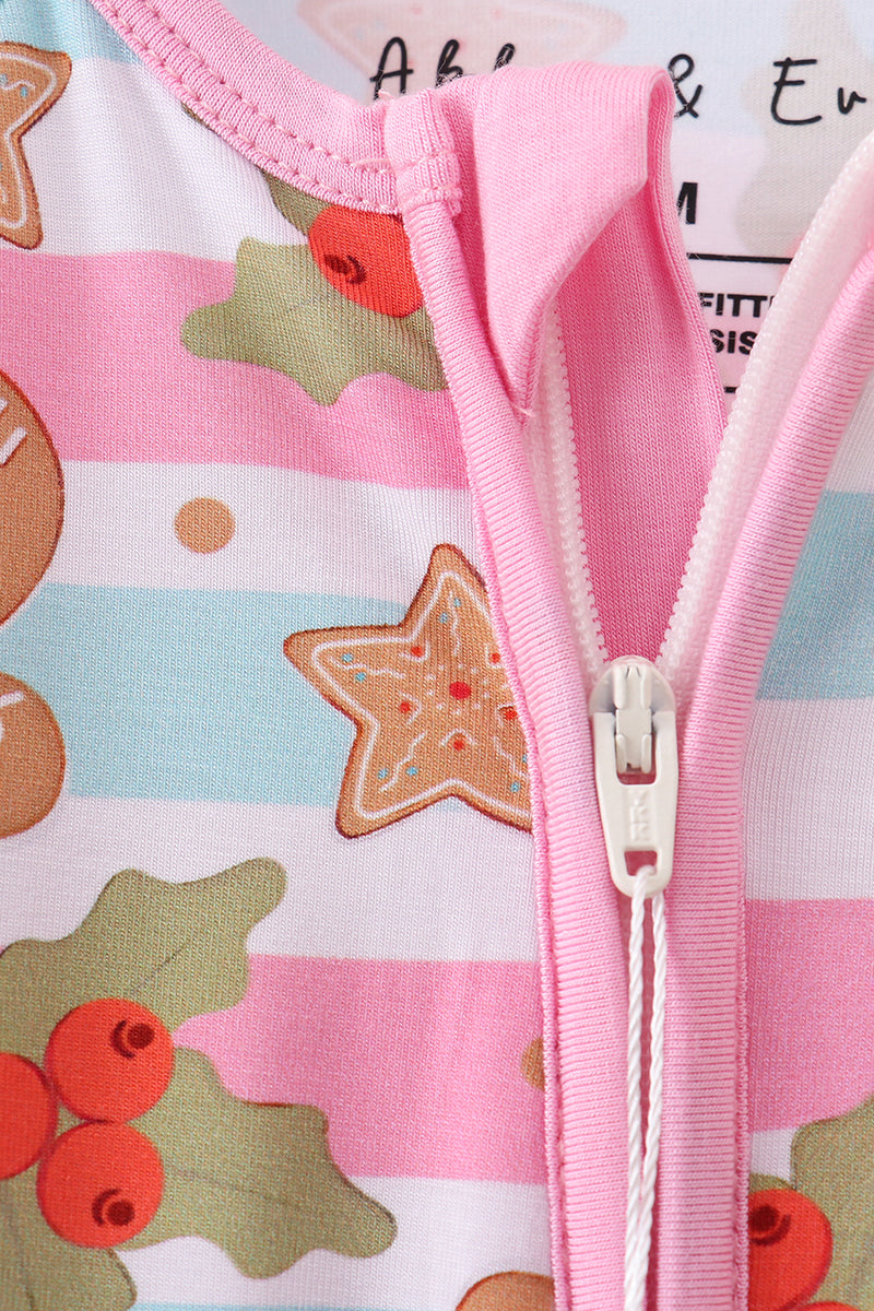 Close-up of a pink zipper on a children's garment with a festive pattern featuring cookies and berries.
