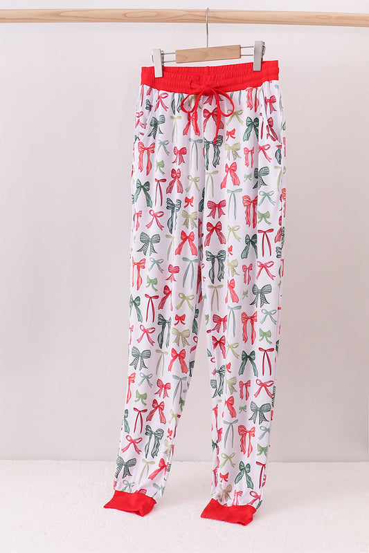 Pajama pants with bow pattern on a hanger against a white background
