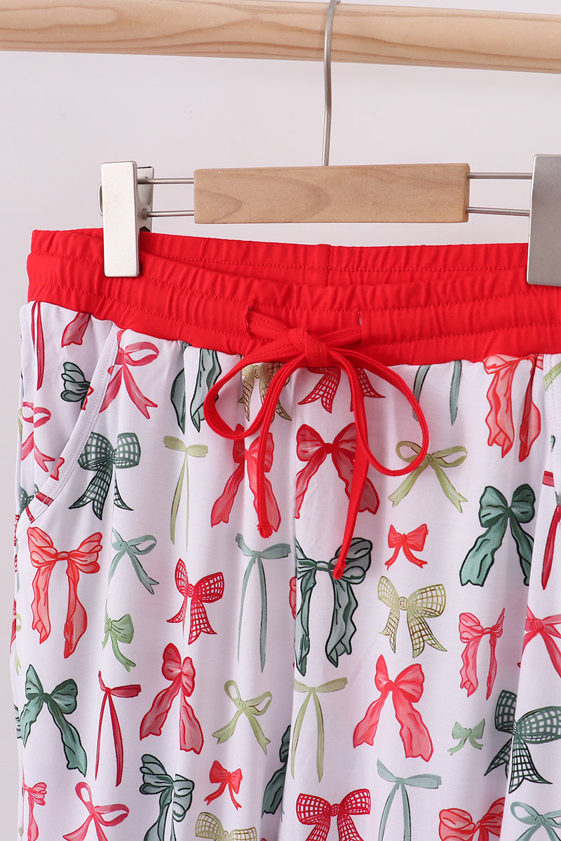 Red top with a white skirt featuring red and green bow pattern on a hanger.
