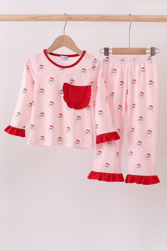 Pink pajama set with Santa Claus pattern on a wooden hanger against a white background