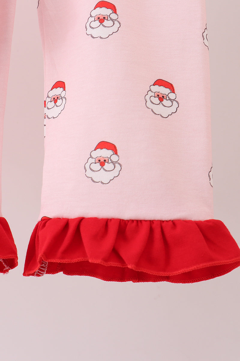 Pink dress with Santa Claus prints and a red ruffled hem on a light pink background