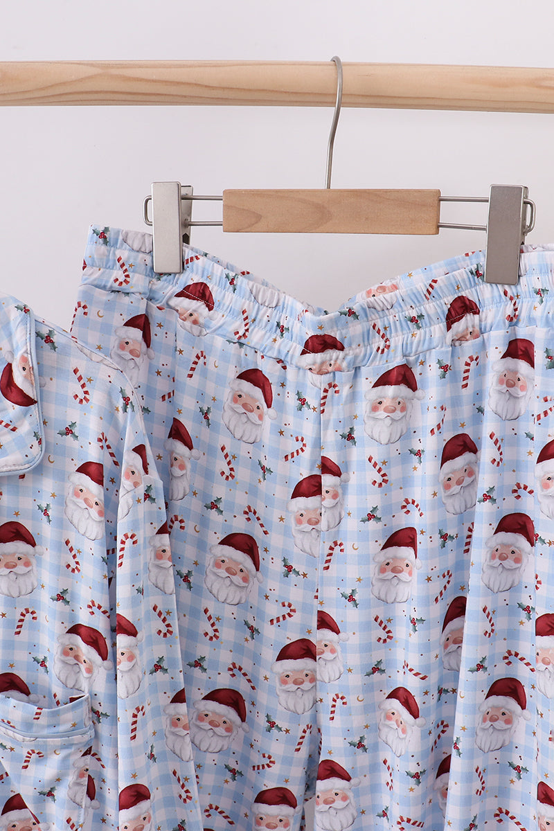 Santa Claus patterned pajama pants hanging on a rack against a white background