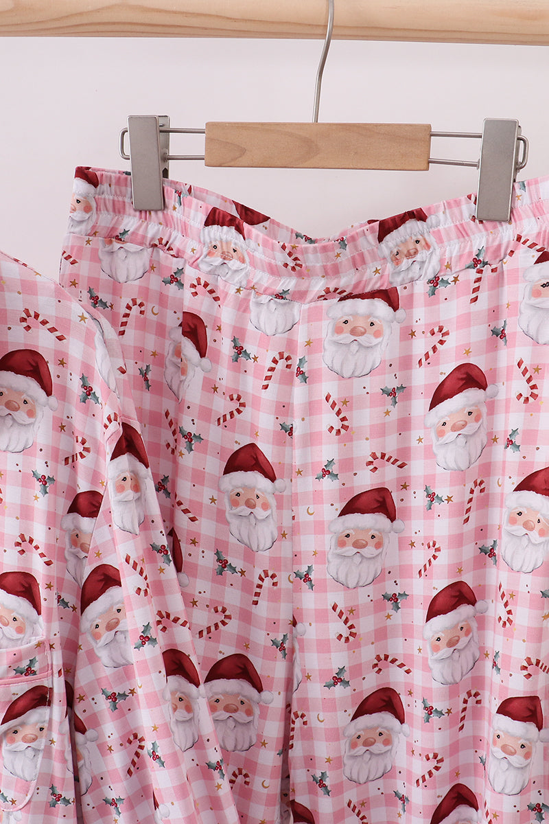 Pink plaid pajama pants with Santa Claus pattern on a hanger.
