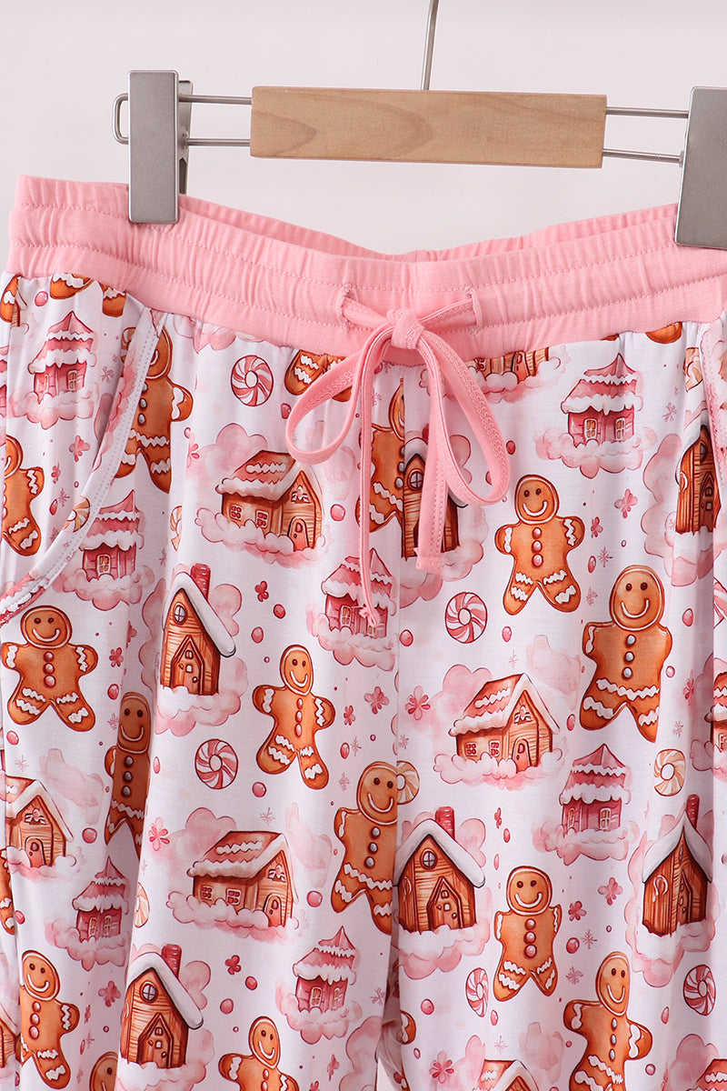 Pajama pants with gingerbread man and house pattern on a hanger.