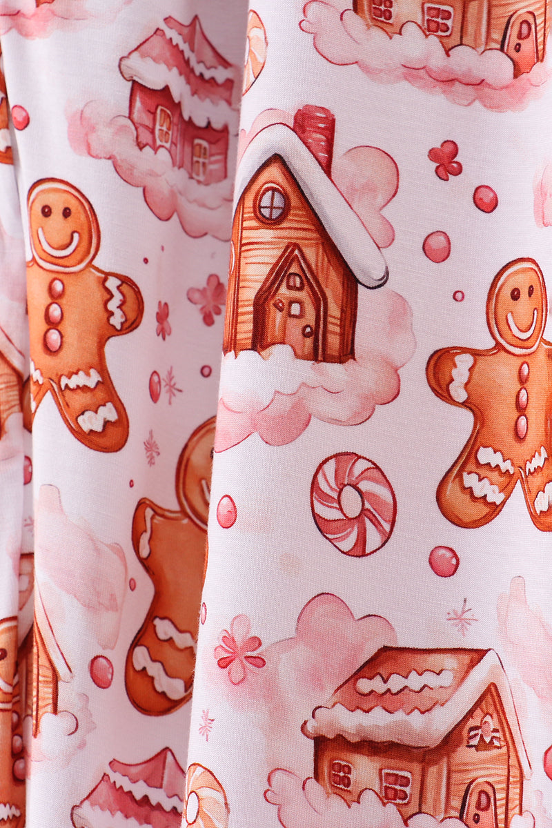 Patterned fabric with gingerbread men, houses, and candy on a white background