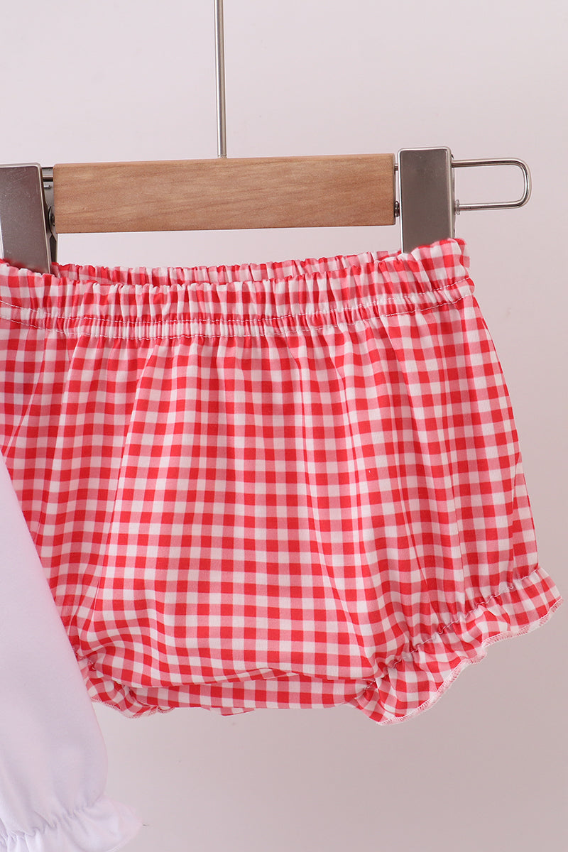 Red and white checkered shorts on a hanger against a light background