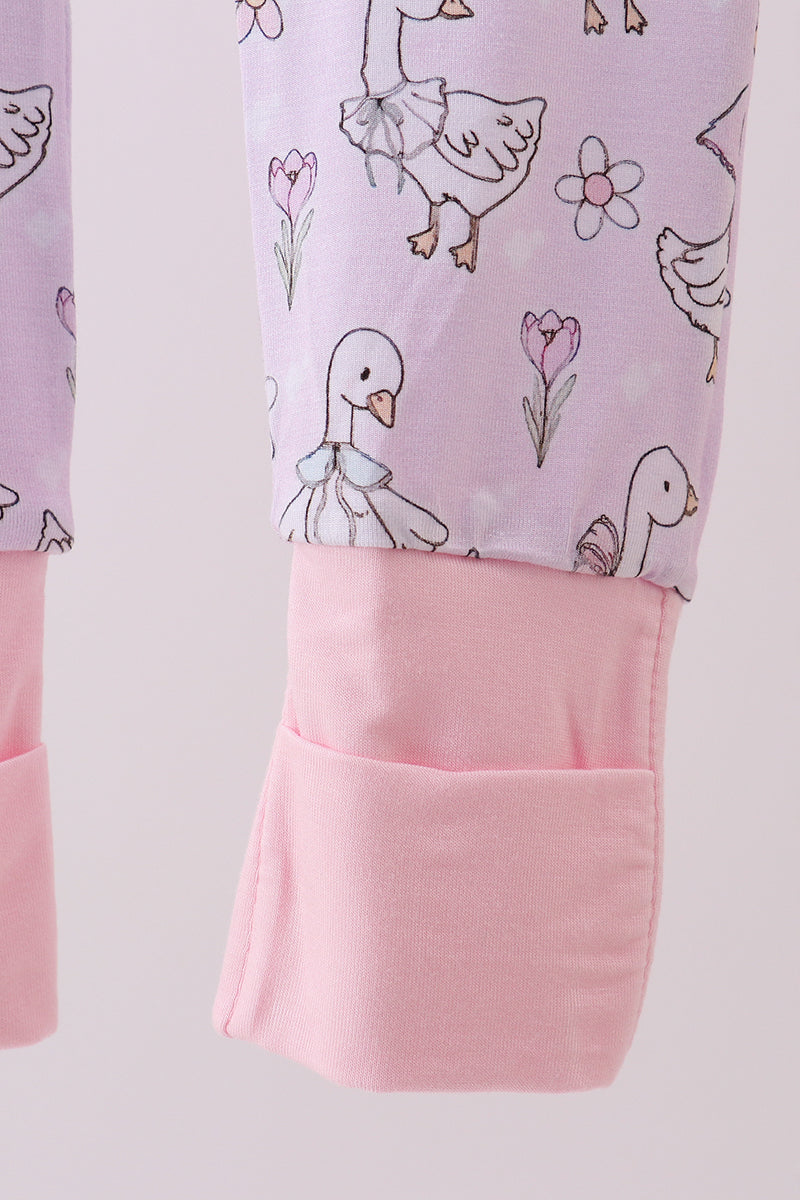 Children's pants with duck and flower pattern on a light purple background