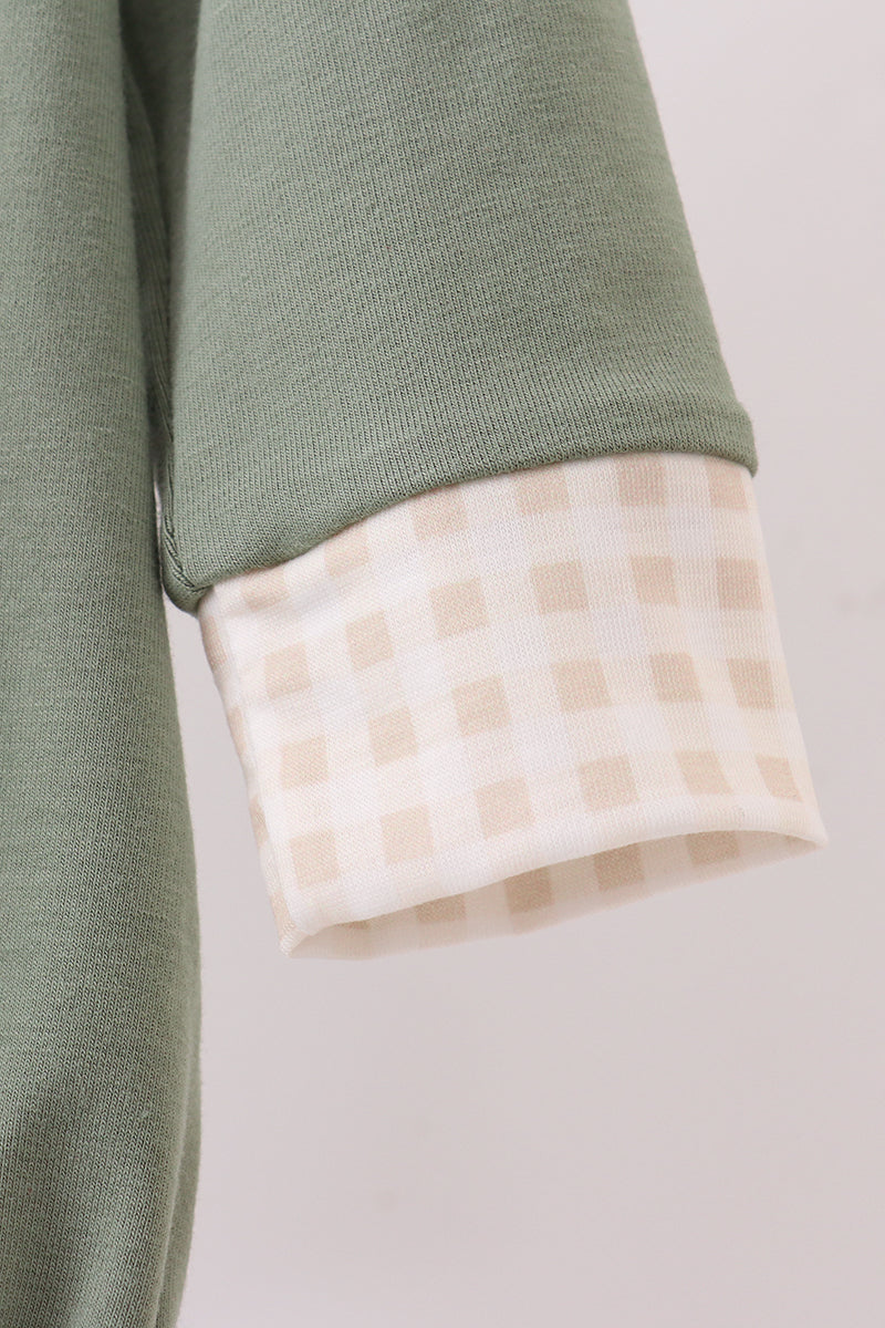 Close-up of a green garment with a checkered lining on a light background