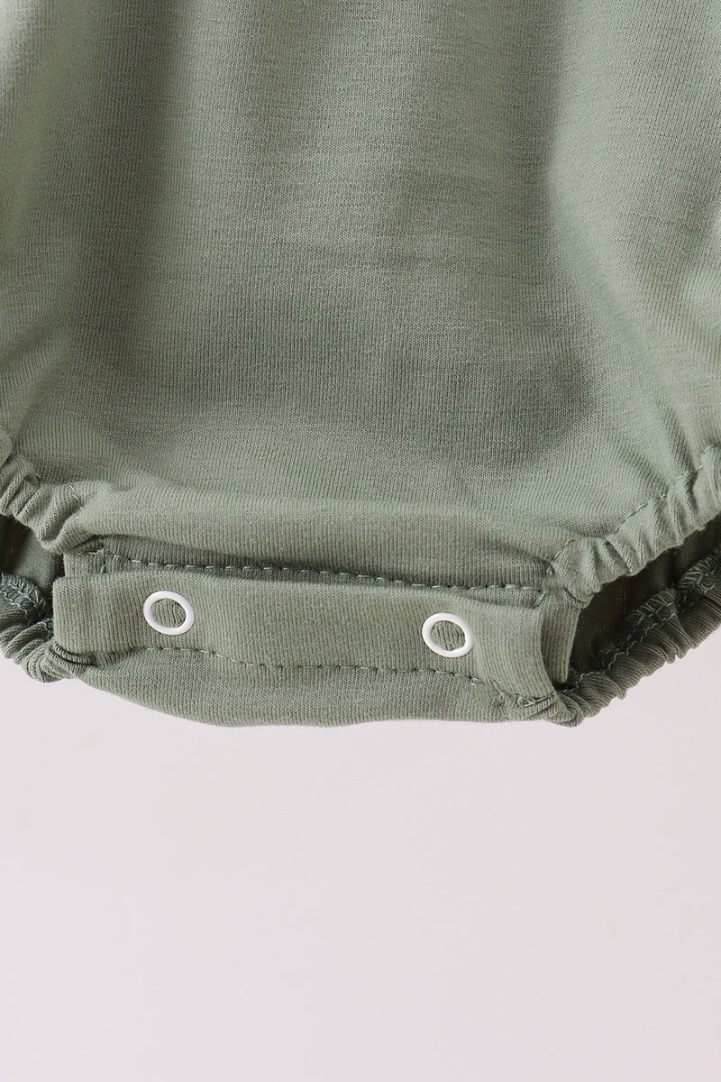 Close-up of a green diaper with button closures on a light gray background