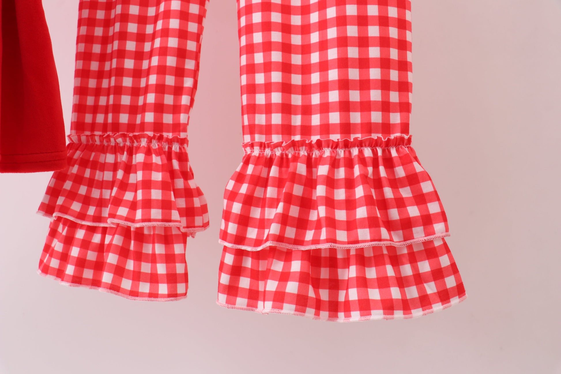 Red and white checkered dress with ruffled layers on a beige background