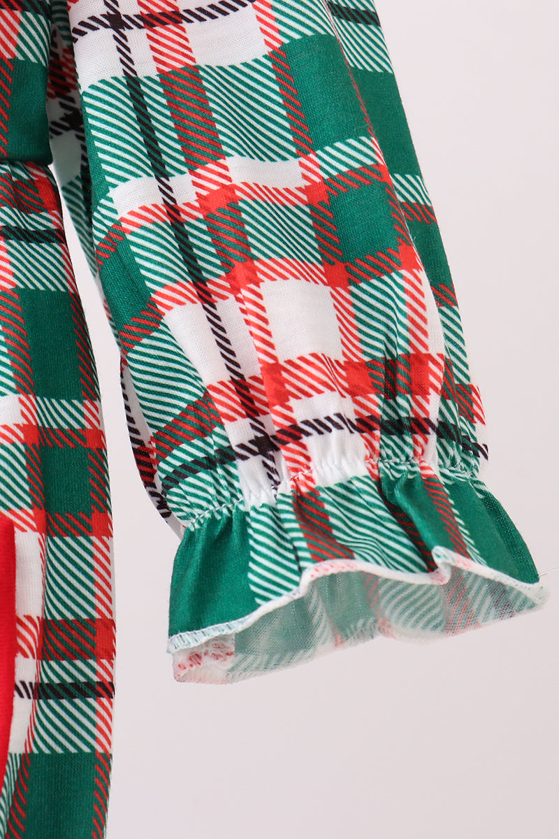 Close-up of green plaid fabric with ruffled edge on a white background