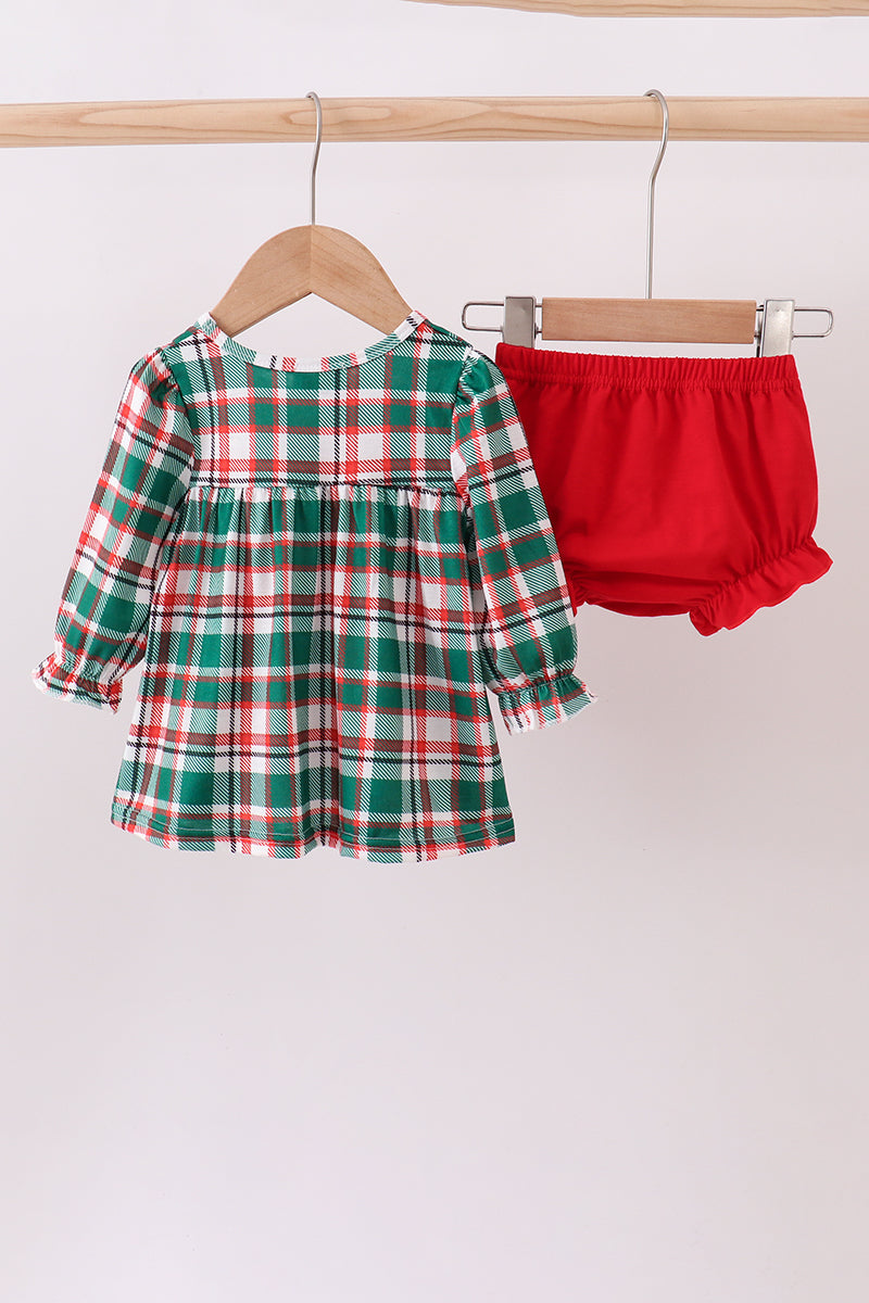 Green plaid dress with red bloomers on hangers against a white background