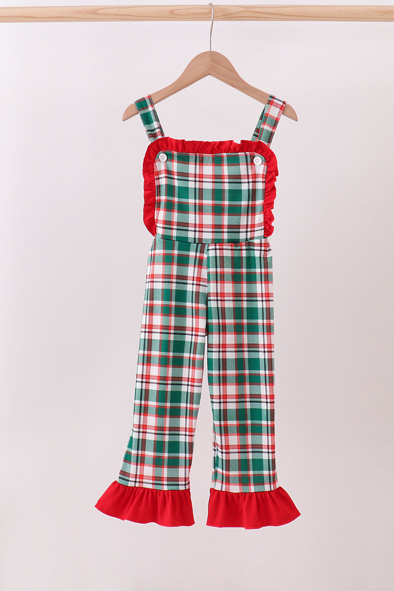 Plaid overalls with red trim on a hanger against a white background