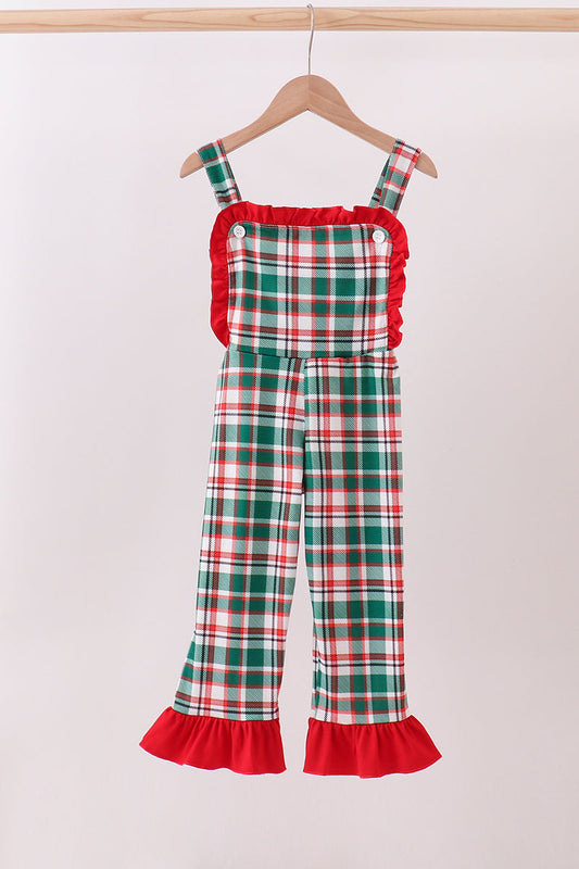 Plaid overalls with red trim on a hanger against a white background