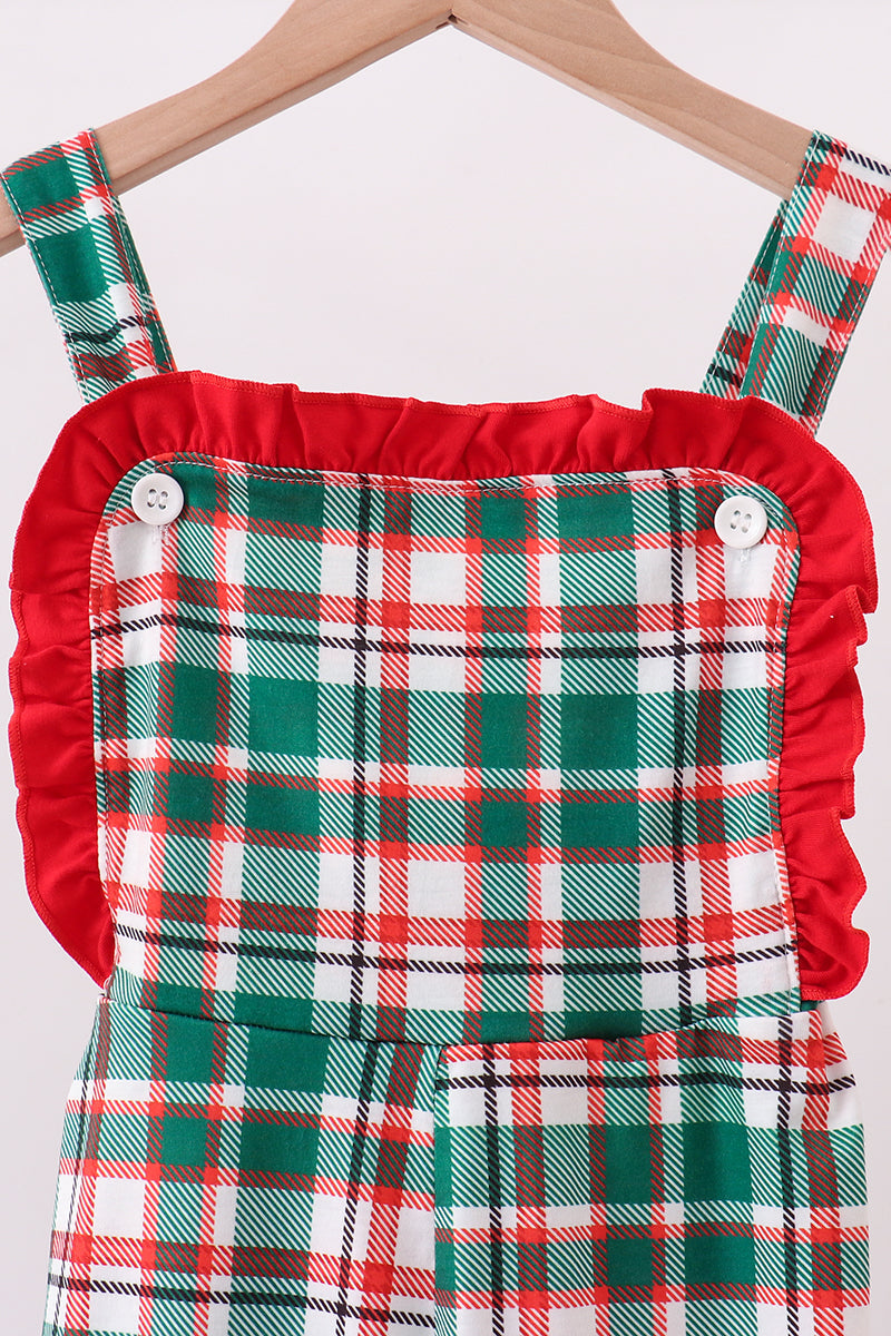 Green and red plaid dress with ruffled red collar on a hanger against a white background