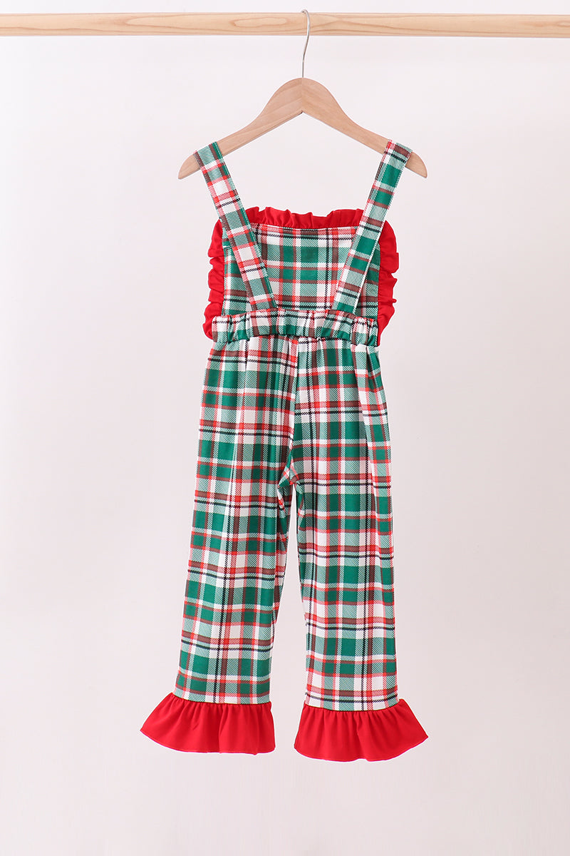 Plaid overalls with red trim on a hanger against a white background