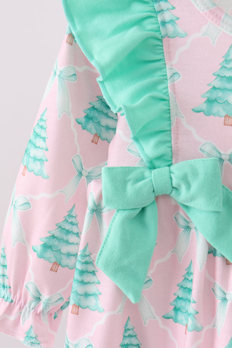Pink fabric with green tree pattern and green trim on a white background