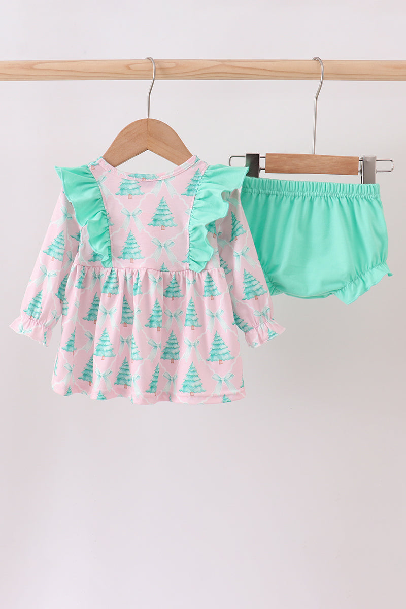 Children's outfit with pink dress and green bloomers on hangers against a white background