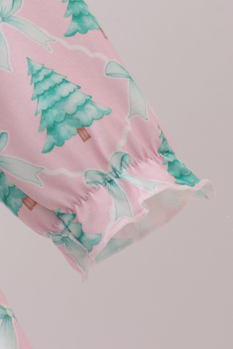 Pink fabric with green tree and white bow pattern on a light gray background