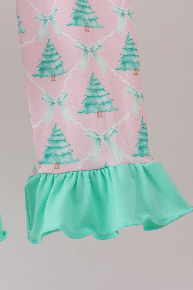 Pink dress with green tree and bow pattern on a light gray background