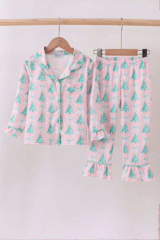 Children's pajama set with tree pattern on a wooden hanger against a white background