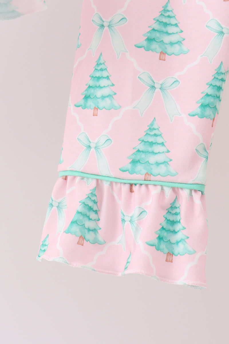 Pink dress with green tree and bow pattern on a light gray background