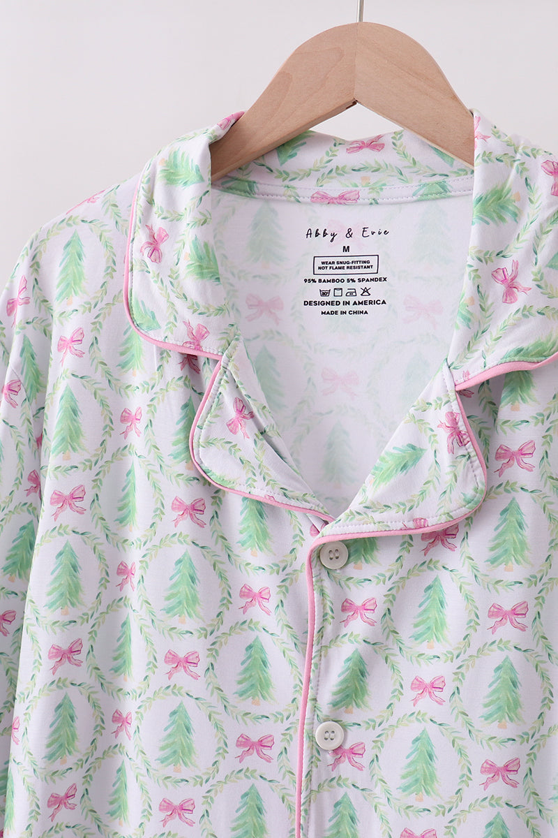Floral patterned shirt with pink and green design on a hanger against a white background