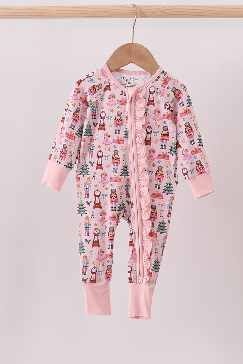 Baby onesie with Christmas pattern on a hanger against a light background