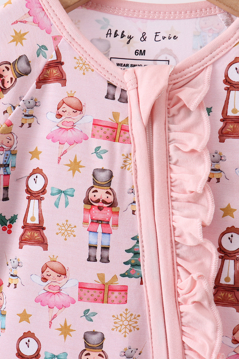 Baby outfit with ruffled pink zipper and Nutcracker-themed design on a pink background