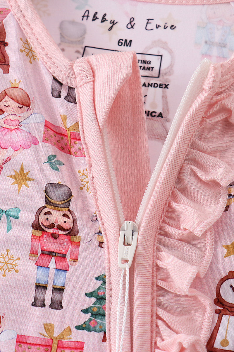 Close-up of a pink jacket with a zipper on a background featuring Christmas-themed illustrations.