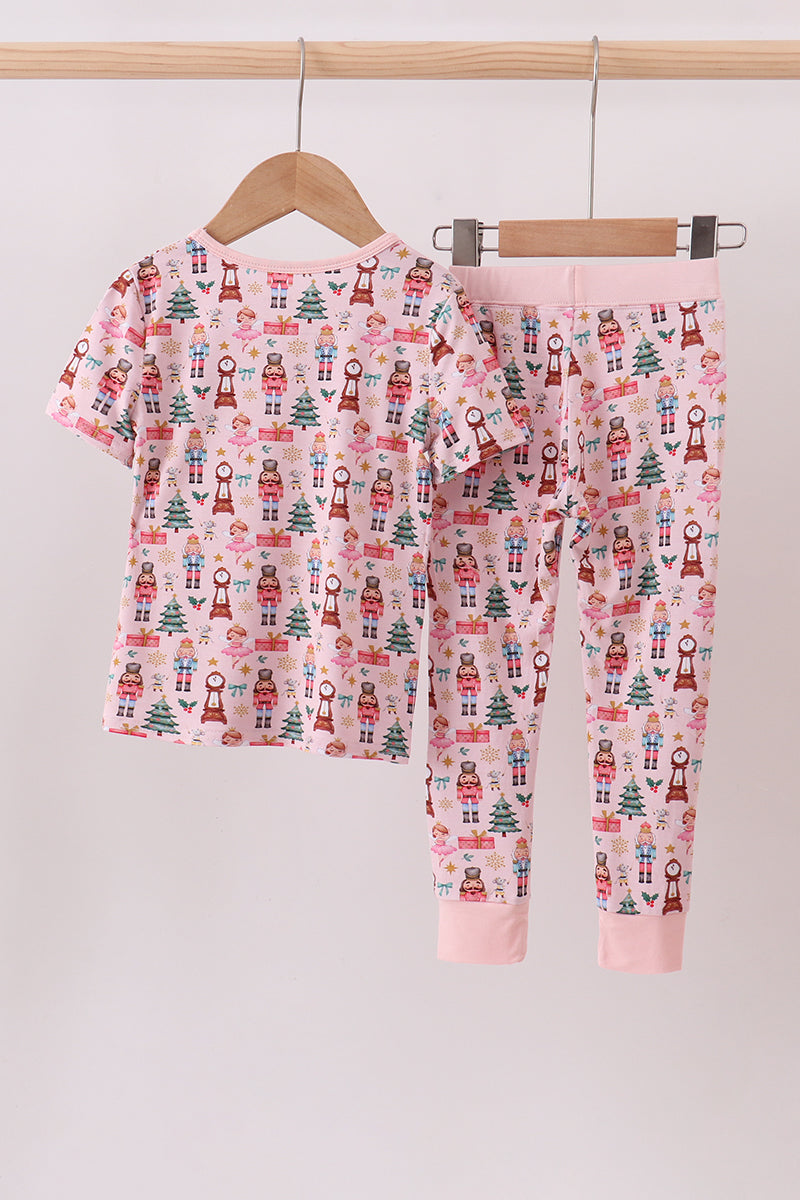 Children's pajama set with Christmas pattern on a hanger against a plain background