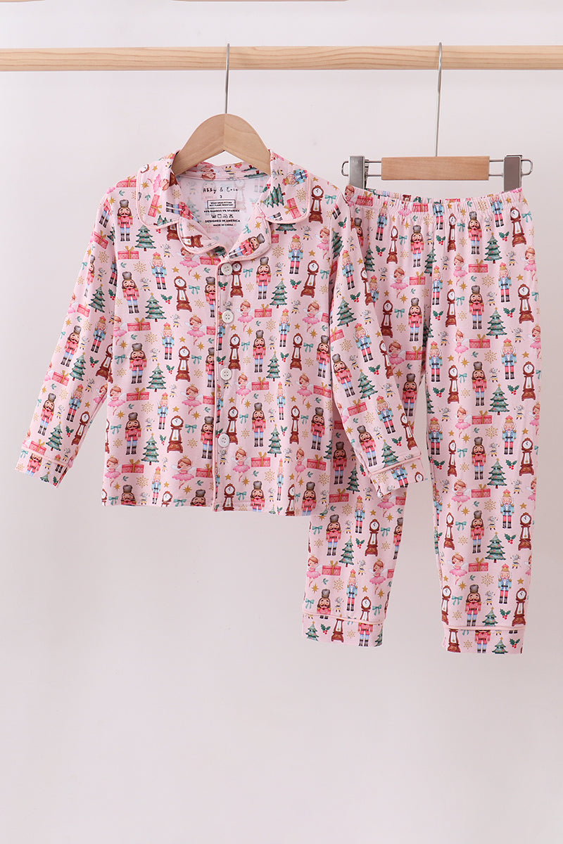 Children's pajama set with nutcracker pattern on a hanger against a white background
