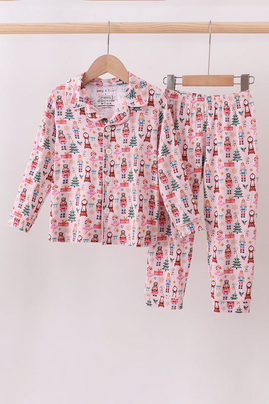 Children's pajama set with nutcracker pattern on a hanger against a white background
