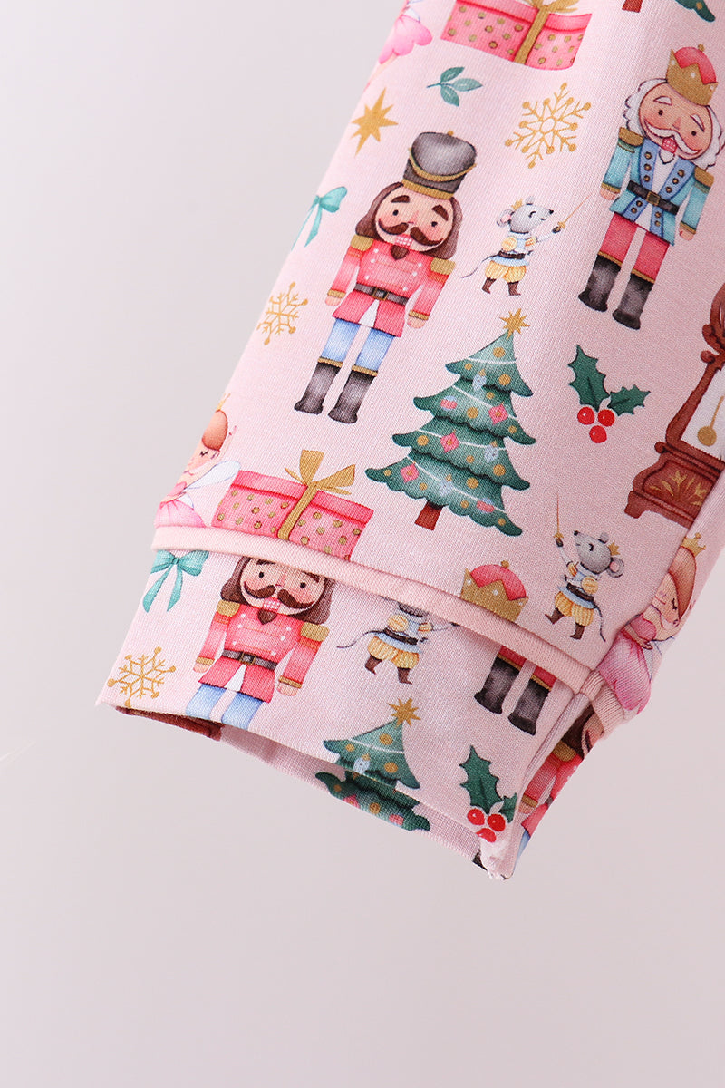 Folded fabric with Christmas-themed design featuring nutcrackers, trees, and presents on a light gray background.