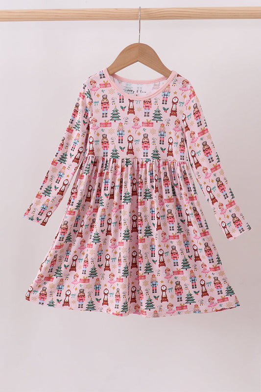 Children's dress with Christmas tree and gift print on a hanger against a white background