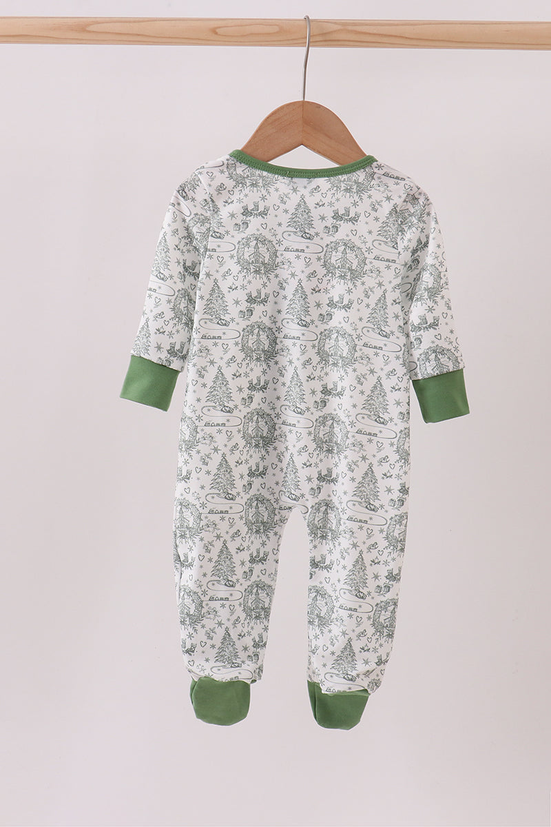 Children's onesie with green and white pattern on a wooden hanger against a light background