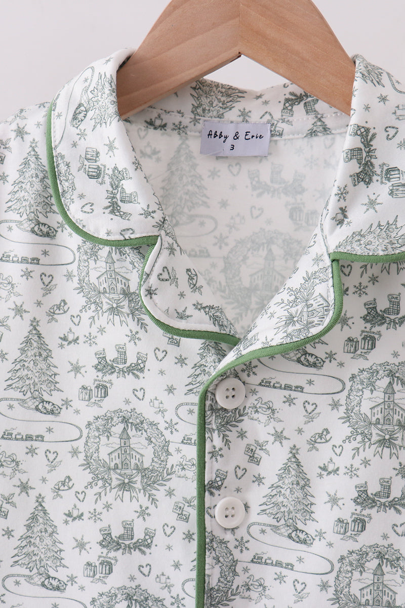 Christmas-themed pajama top with green trim on a hanger