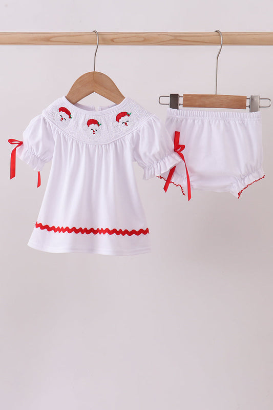 White baby outfit with red accents on hangers against a white background