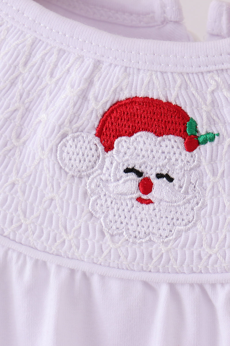 Embroidered face design on a white fabric with a red hat and black eyes.