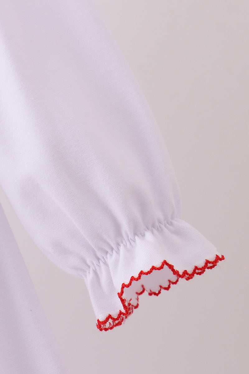 White garment with red trim on a light gray background