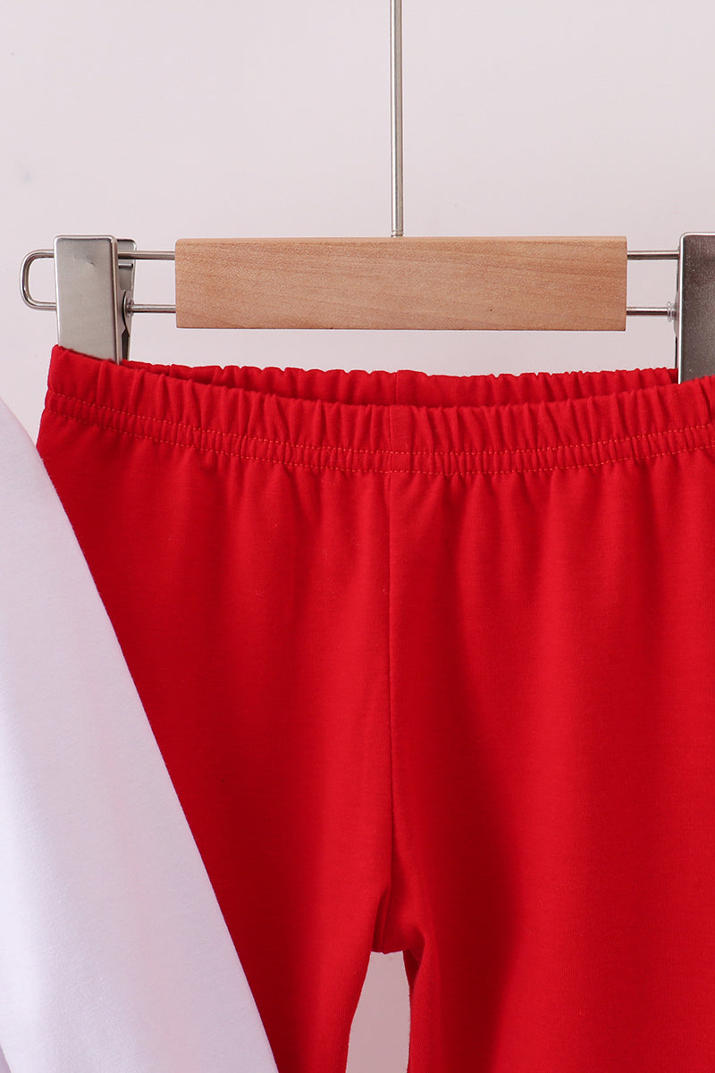 Red pants on a wooden hanger against a white background