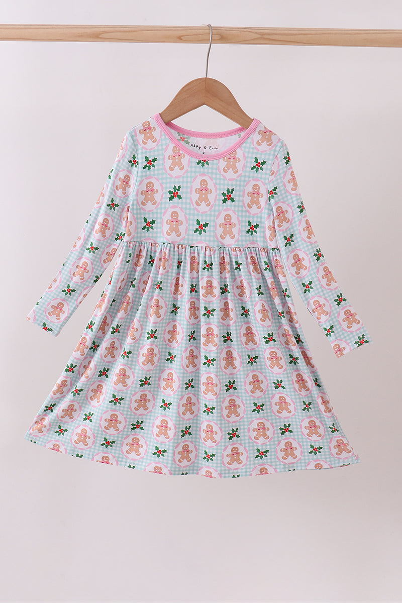 Children's dress with gingerbread man pattern on a hanger against a white background