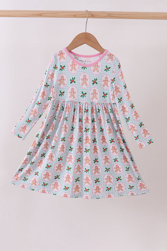 Children's dress with gingerbread man pattern on a hanger against a white background