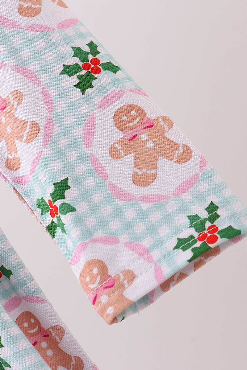 Fabric with gingerbread man and holly pattern on a checkered background