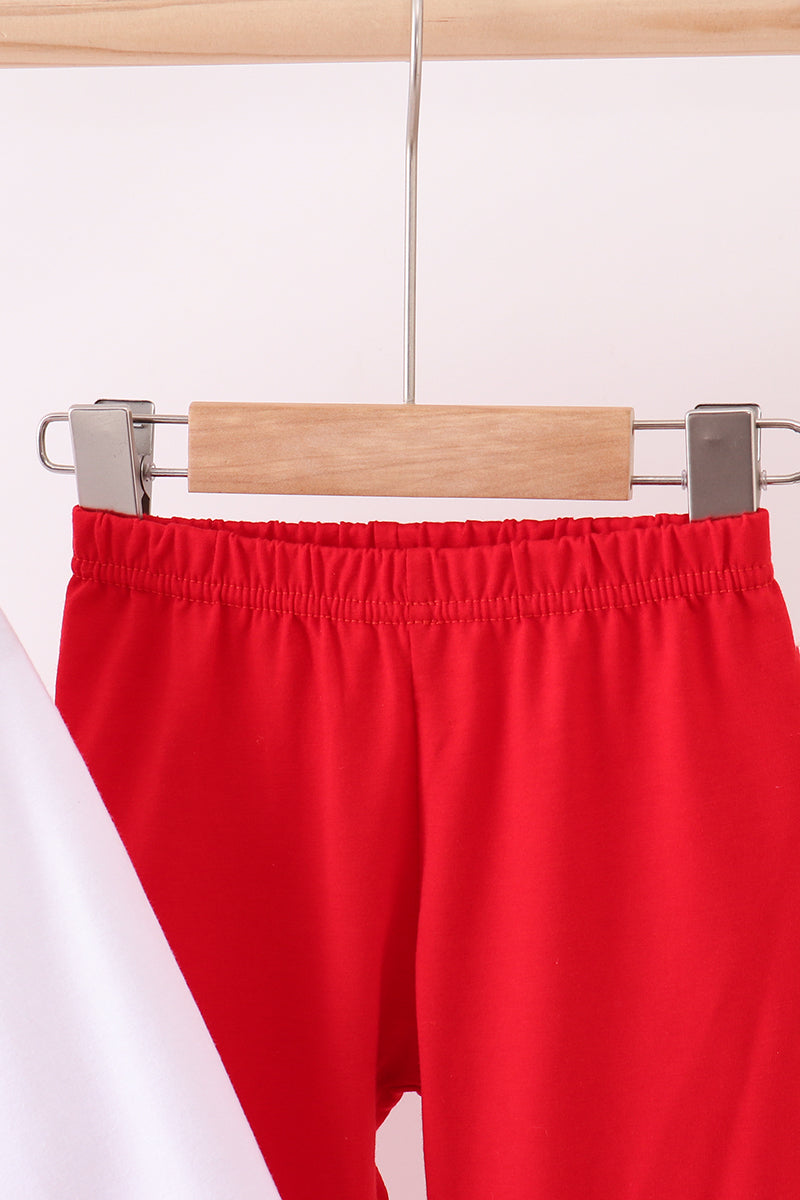 Red pants on a wooden hanger against a white background