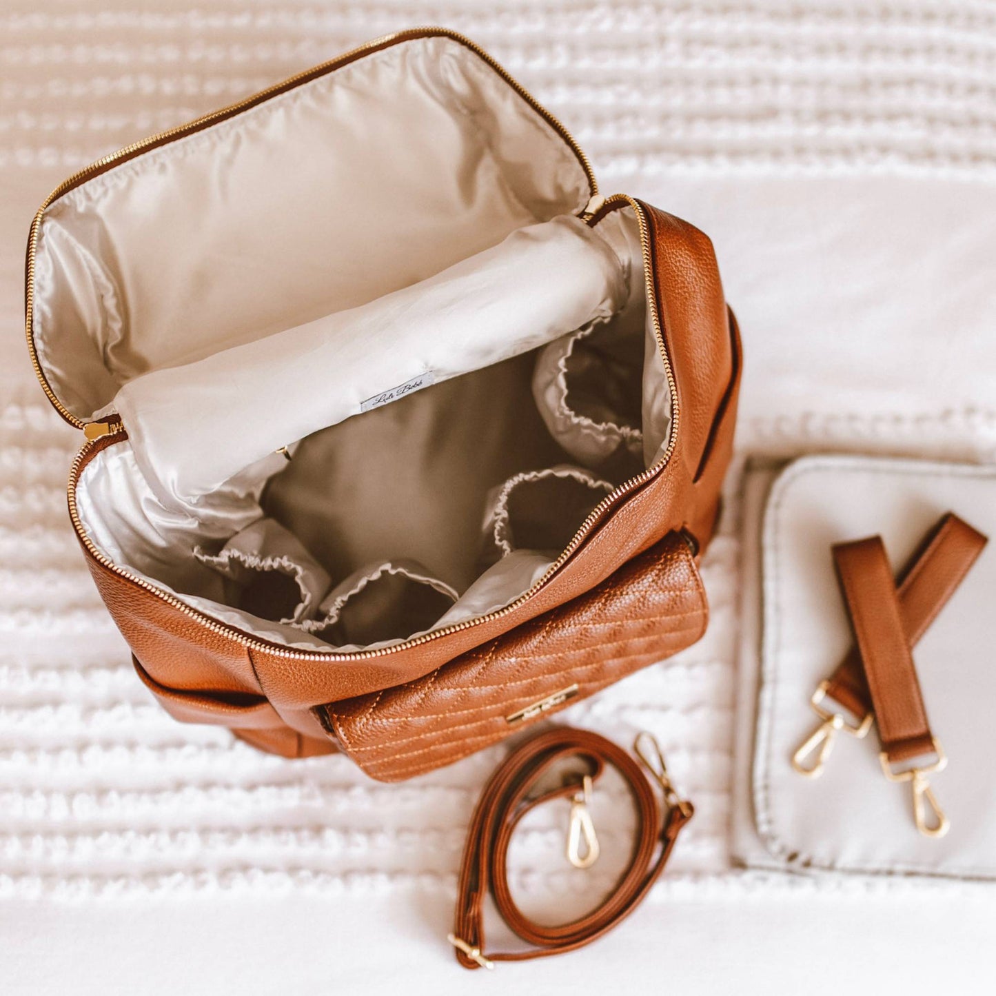 Brown quilted handbag with strap on a textured surface